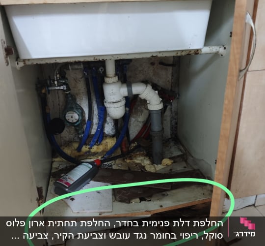ארון מטבח פתוח עם צנרת ודליפה